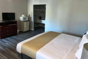 a hotel room with a bed and a television at Travelodge by Wyndham Redding CA in Redding