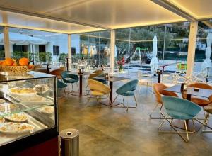 a restaurant with tables and chairs and a counter with food at Resort Petrasia in Villammare