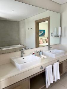 ein Badezimmer mit zwei Waschbecken und einem großen Spiegel in der Unterkunft Villa Luxury Anahita in Grande Rivière Sud Est