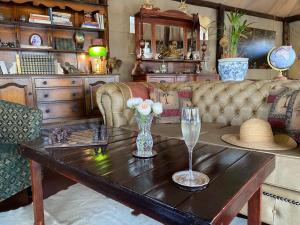 ein Wohnzimmer mit einem Sofa und einem Tisch mit einem Glas Wein in der Unterkunft Out in Africa Wildlife Lodge in Dinokeng Game Reserve