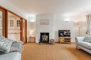 a living room with a couch and a fireplace at Astley House - Norfolk Cottage Agency in Blakeney