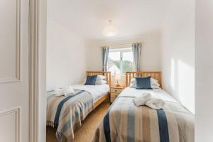 sypialnia z 2 łóżkami i oknem w obiekcie Astley House - Norfolk Cottage Agency w mieście Blakeney
