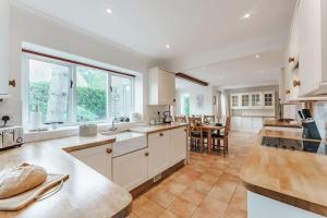 a large kitchen with white cabinets and a table at Astley House - Norfolk Cottage Agency in Blakeney