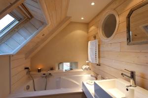 a large bathroom with a tub and a sink at Le Lodge Kerisper in La Trinité-sur-Mer