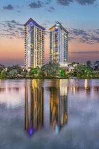 two tall buildings are reflected in a body of water at Hilton Batumi in Batumi