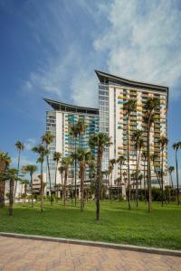 a large building with palm trees in front of it at Hilton Batumi in Batumi