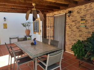a dining table and chairs in a room with a brick wall at Cortijo Ramonsillos in Villanueva del Trabuco