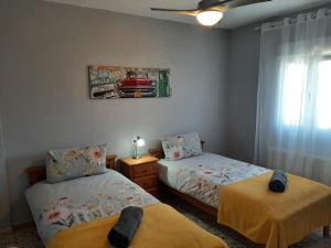 1 dormitorio con 2 camas y ventana en Cortijo Ramonsillos en Villanueva del Trabuco