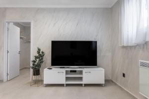 a living room with a television on a white cabinet at JOY APARTMENTS Zemun,Beograd in Zemun