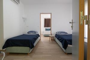 a bedroom with two beds and a mirror at Les Oliviers - Studios & Apartments in Vourvourou