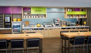 a restaurant with tables and chairs in a kitchen at Home2 Suites By Hilton Brantford in Brantford