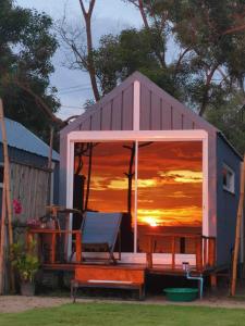 une maison de jeux avec une réflexion sur le coucher du soleil dans la fenêtre dans l'établissement Walden Koh Lanta - Tiny Homes by the Sea, à Ko Lanta