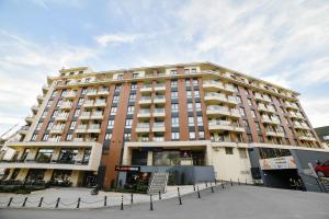 a large apartment building in front of a parking lot at Kraljev trg - lux apartman in Zlatibor