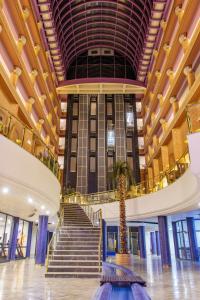 a lobby with a palm tree in the middle of a building at Anadolu Hotels Esenboga Thermal in Esenboga