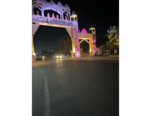 an arch with purple lights on a street at night at Excel Hotel, Somnath in Somnath