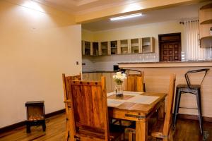 a kitchen with a wooden table with a vase of flowers on it at TJ's Boutique Hotel in Eldoret