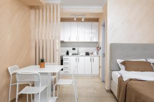Ce petit appartement comprend un lit, une table et des chaises. dans l'établissement JOY APARTMENTS Zemun,Beograd, à Zemun