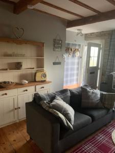 een woonkamer met een bank en een keuken bij Hays cottage in Halifax