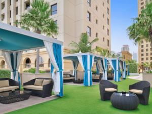 a group of gazebos on a lawn in a hotel at Mövenpick Hotel Jumeirah Beach in Dubai