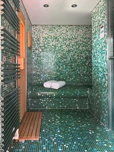 a bathroom with a shower with green tiles at Das Himmelhaus Sot il Pegn in Lenzerheide