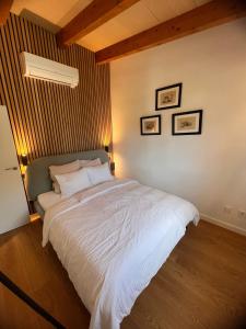 a bedroom with a large white bed with three pictures on the wall at Los Dos Caballeros Winery & Vacation Rental in Llubí