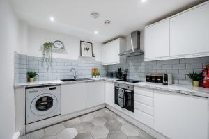 uma cozinha com armários brancos e uma máquina de lavar roupa em Host & Stay - Halifax House Living em Liverpool