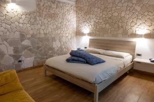 1 dormitorio con cama y pared de piedra en tulipano rosso en Bari