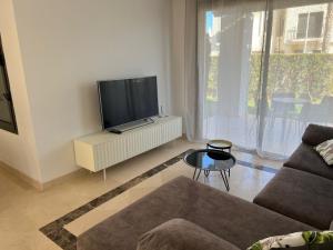 een woonkamer met een bank en een tv bij Moderno y acogedor adosado en Roda Golf Resort in Roda