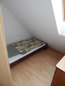 uma pequena cama sentada no canto de um quarto em Ferienhaus Seepferdchen Neßmersiel em Neßmersiel