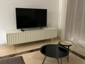 ein Wohnzimmer mit einem Flachbild-TV auf einem Entertainment-Center in der Unterkunft Moderno y acogedor adosado en Roda Golf Resort in Roda