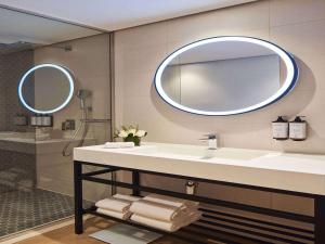 La salle de bains est pourvue d'un lavabo et d'un miroir. dans l'établissement Adagio Jumeirah Village Triangle, à Dubaï