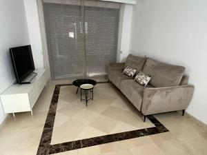 ein Wohnzimmer mit einem Sofa und einem TV in der Unterkunft Moderno y acogedor adosado en Roda Golf Resort in Roda