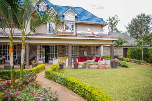 a house with a garden with red chairs and flowers at The Blixen Resort & Spa in Nairobi