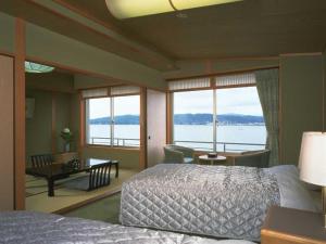 a bedroom with a bed and a view of the water at Naniwa Issui in Matsue