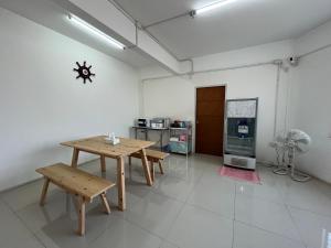 une chambre avec une table et une cuisine avec une cuisinière dans l'établissement Dao Jaras Fah Hometel ดาวจรัสฟ้าโฮมเทล, à Bangkok