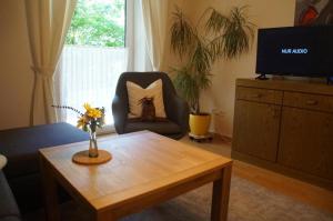 ein Wohnzimmer mit einem Couchtisch und einem Stuhl in der Unterkunft Gästehaus Brunner in Zwiesel