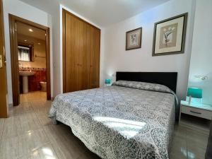 een slaapkamer met een groot bed en een badkamer bij ACV - Costa Marina II - 1ª linea planta 6 sur in Oropesa del Mar