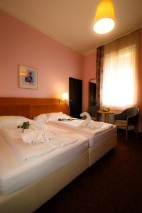 a hotel room with a bed with towels on it at Wellness Penzion Kroměříž - Zlobice in Kroměříž