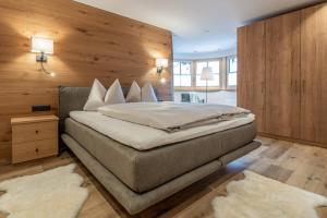 a bedroom with a large bed with a wooden wall at Weinleinshof Appartements in Vent