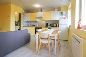 una cucina e una sala da pranzo con tavolo e sedie di Appartement sans vis-à-vis proche du centre-ville a Douai