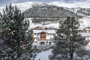 a resort in the snow with two trees at Weinleinshof Appartements in Vent