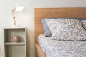 un letto con cuscino e lampada su un comodino di Appartement sans vis-à-vis proche du centre-ville a Douai