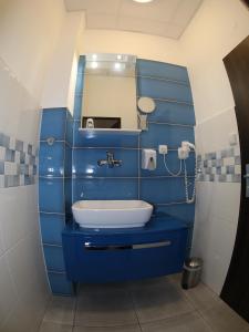niebieska łazienka z umywalką i lustrem w obiekcie Wellness Penzion Kroměříž - Zlobice w Kromieryżu