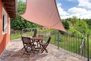 un patio con mesa, sillas y una valla en Agriturismo - Tenuta MonteOliveto - Cottage Relax, en Vesime