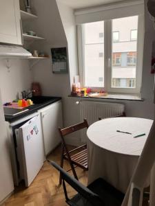 a kitchen with a table and a kitchen with a table and chairs at Stay in maison de metre in Etterbeek in Brussels +21 photos