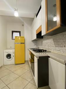 una cucina con frigorifero giallo e lavatrice di B & B IL VICOLETTO a Pontecorvo