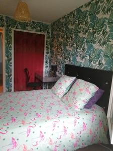 ein Schlafzimmer mit einem Bett mit rosa Schmetterlingen darauf in der Unterkunft Appartdom in Angoulême