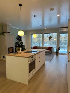 a kitchen with a white island in a living room at Brand New! Villa Moon in Rovaniemi