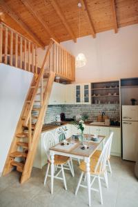 a kitchen with a wooden table with chairs and a staircase at Villa di Vino in Lefkada Town