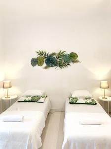 two beds in a room with plants on the wall at Alcântara Studio 15 in Lisbon